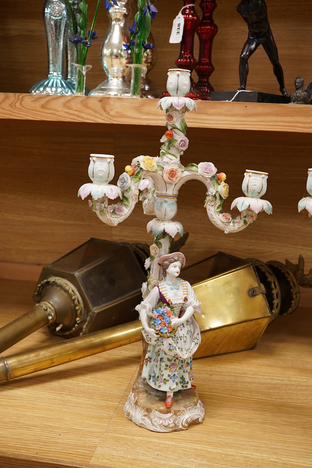 A pair of Volkstedt porcelain figural three branch candelabra with floral encrusted decoration, 51cm high